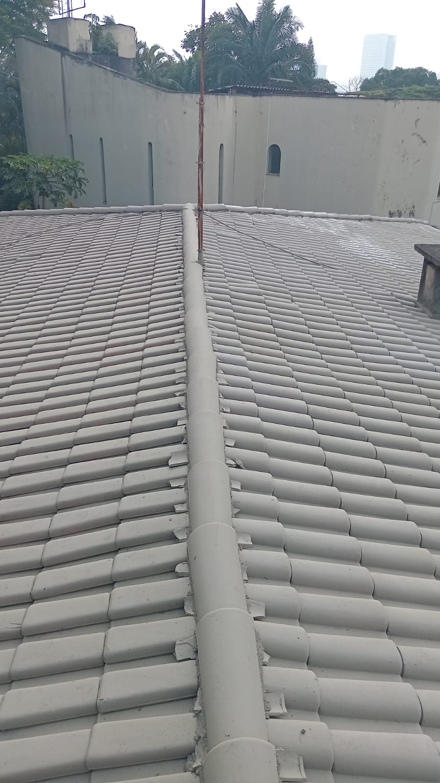 Alinhamento e vedação de cumeeiras em telhado cinza